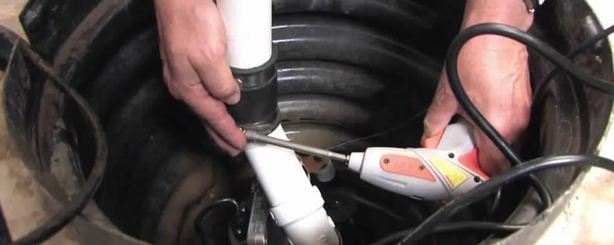 Sump pump installation technician connecting PVC discharge piping in Louisville, KY